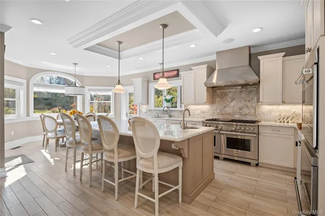 a kitchen with stainless steel appliances granite countertop a stove top oven a sink dishwasher a dining table and chairs with wooden floor