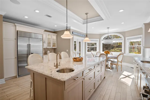 a kitchen with stainless steel appliances granite countertop a kitchen island a stove a table and chairs