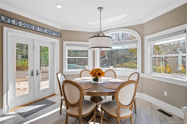 a dining room with furniture a chandelier and wooden floor