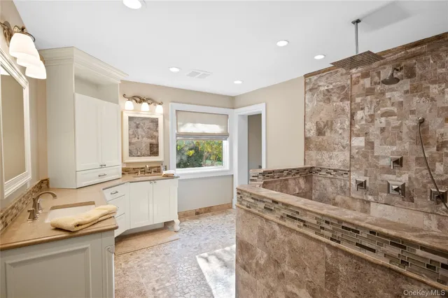 a spacious bathroom with a granite countertop tub a double vanity sink and large window