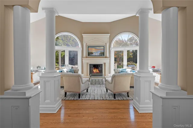a living room with fireplace furniture and a large window