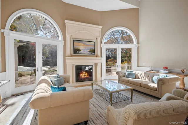 a living room with furniture a fireplace and a large mirror