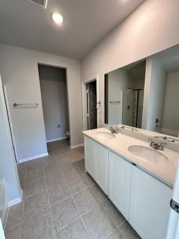 a spacious bathroom with a double vanity sink and a mirror