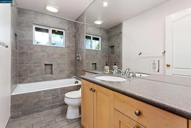a bathroom with a double vanity sink toilet and shower
