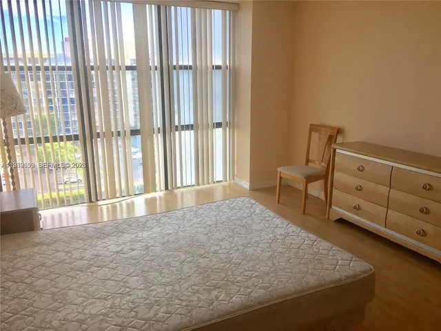 a bedroom with a large bed and a large window