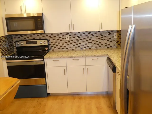 a kitchen with stainless steel appliances a stove and a refrigerator