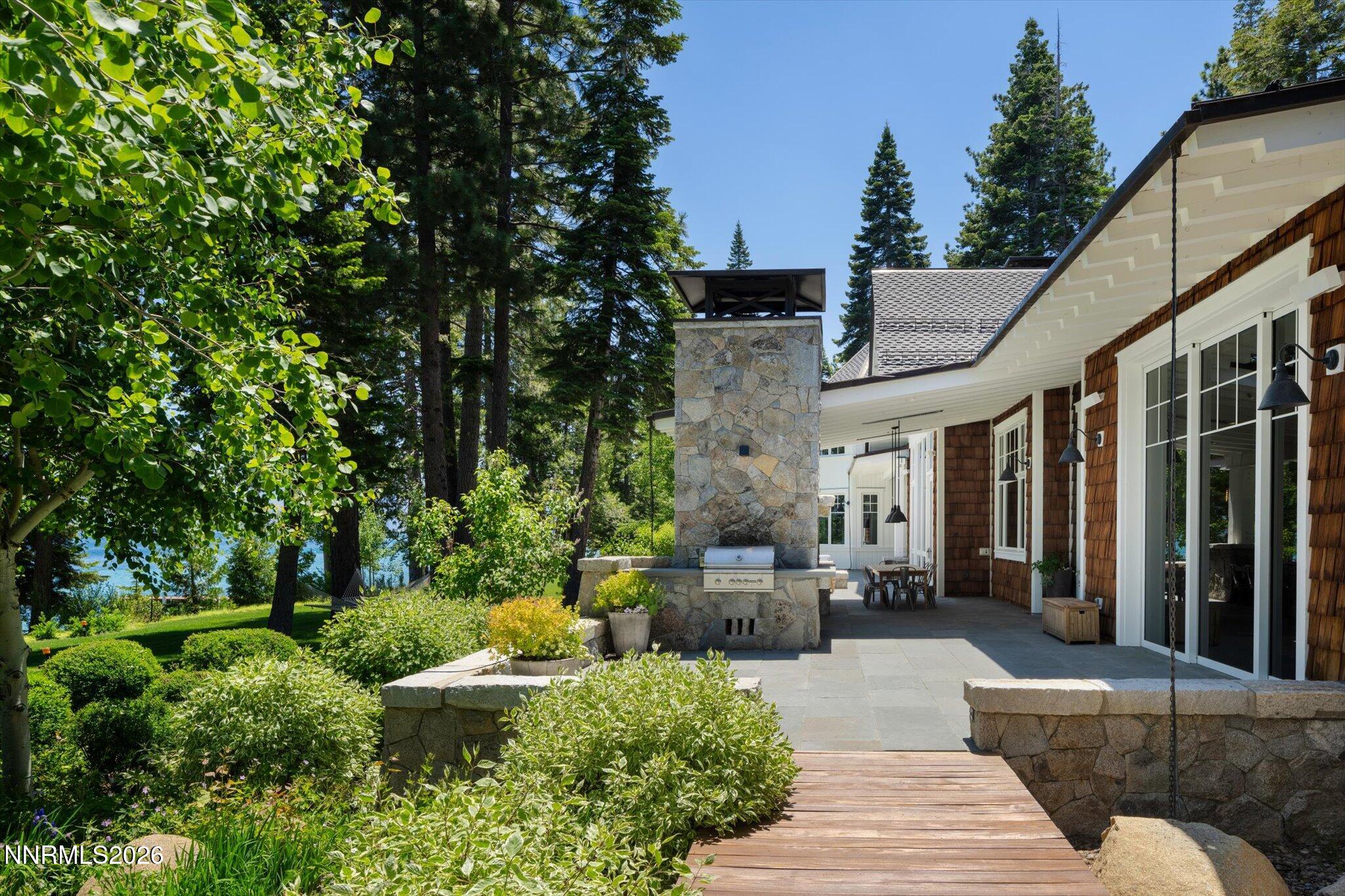 226 4 Ring Road Tahoma, CA 96142 - Photo 35 of 41 a view of a patio with couches table and chairs under an umbrella with large trees