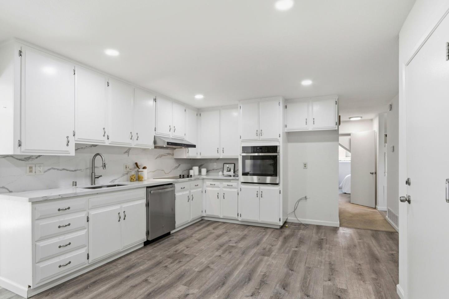 546 Woodstock Way Santa Clara, CA 95054 - Photo 7 of 24 a kitchen with white cabinets and stainless steel appliances