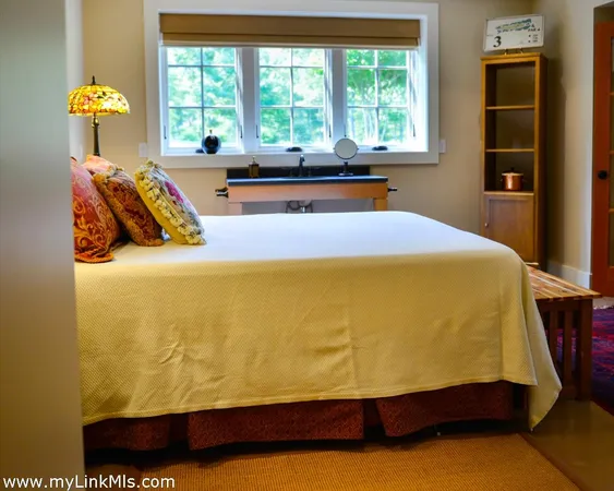a bed sitting in a bedroom next to a window