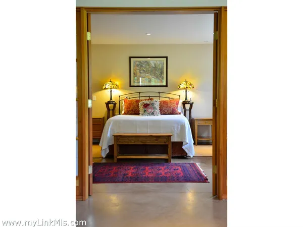 a bedroom with a bed and a painting on the wall