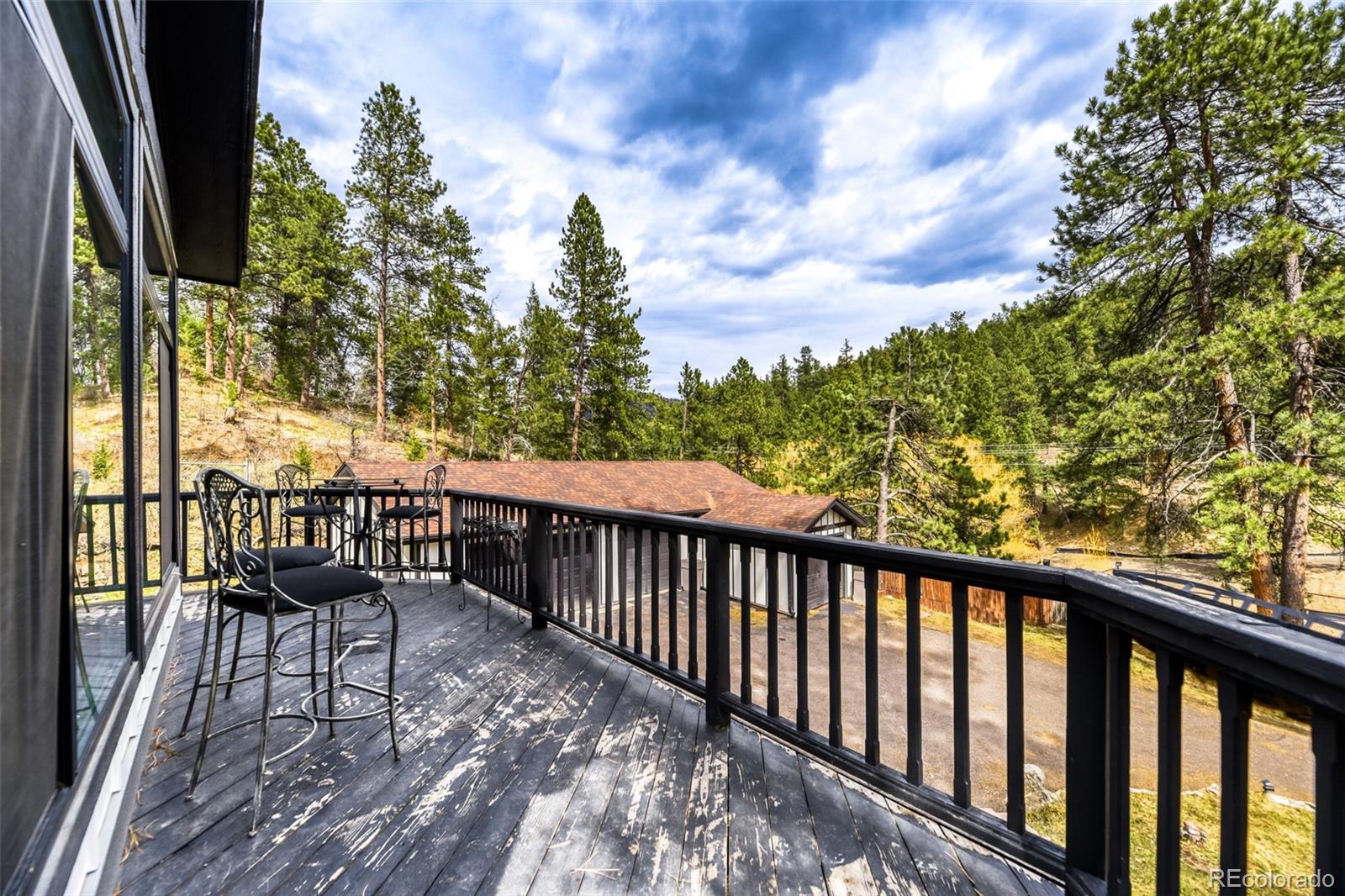 7489 South Turkey Creek Road Morrison, CO 80465 - Photo 26 of 28 a view of a balcony with chairs and wooden fence