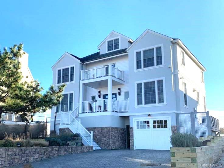 View of front of property featuring a garage and balconies