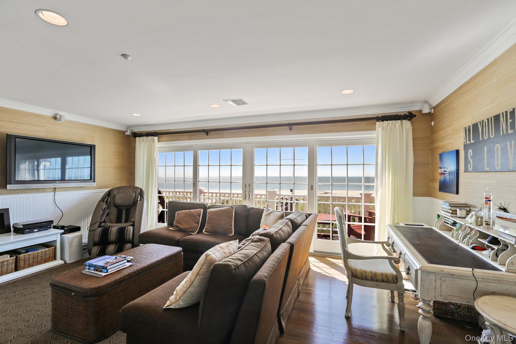 949 B Dune Road West Hampton Dunes, NY 11978 - Photo 8 of 19 Living room with crown molding, a water view, plenty of natural light, and dark hardwood / wood-style flooring