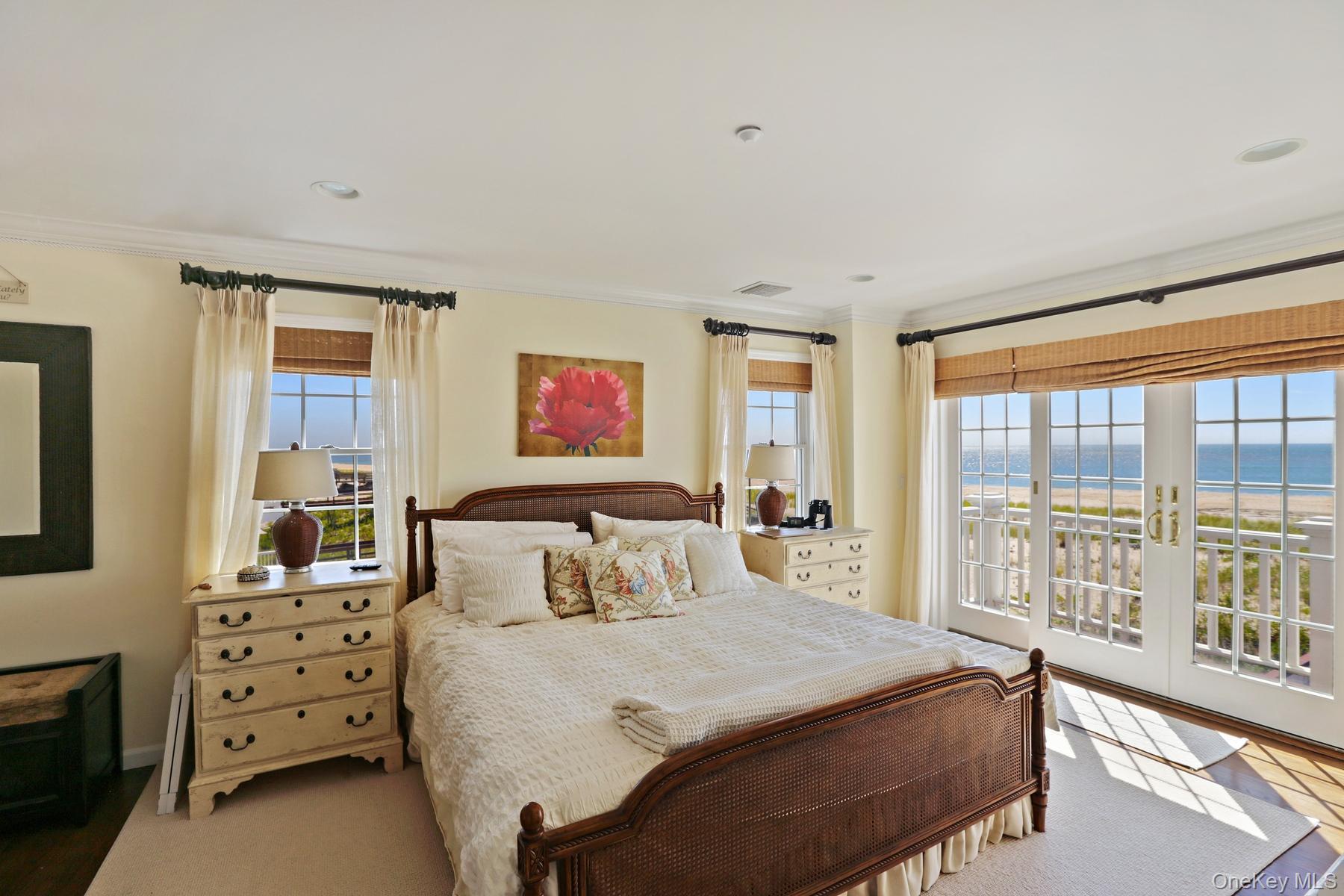 949 B Dune Road West Hampton Dunes, NY 11978 - Photo 9 of 19 Bedroom with multiple windows, crown molding, a water view, and access to exterior