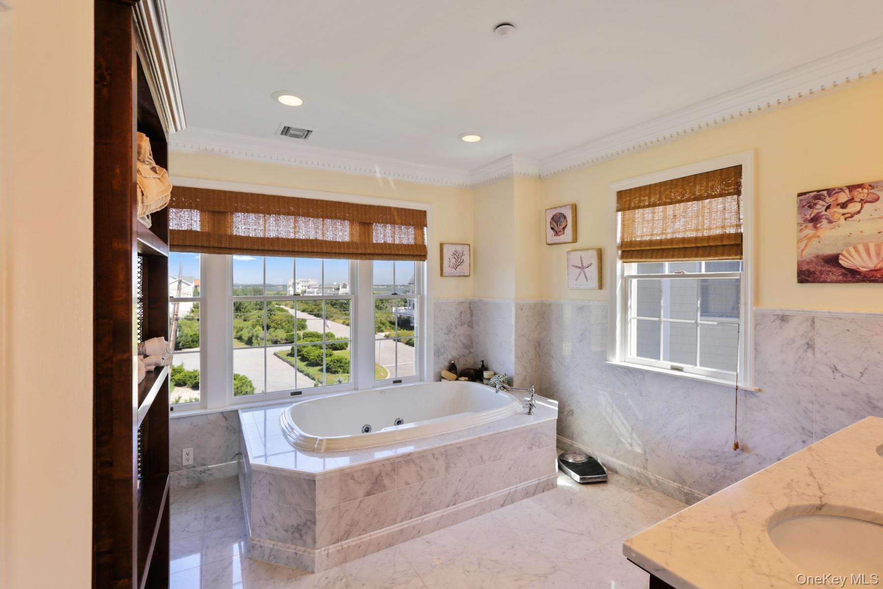 949 B Dune Road West Hampton Dunes, NY 11978 - Photo 10 of 19 Bathroom with a relaxing tiled tub, vanity, crown molding, and tile walls