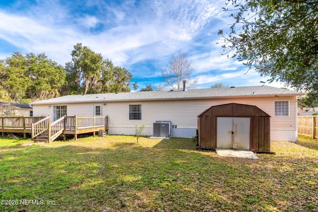 a view of a house with backyard wooden fence and sitting area