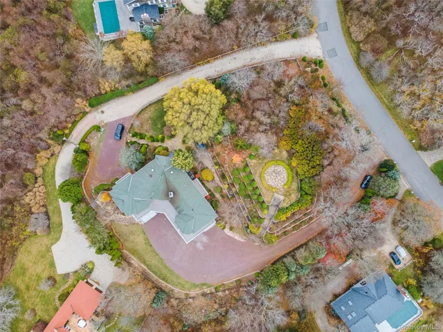 an aerial view of a house with a yard and a large tree
