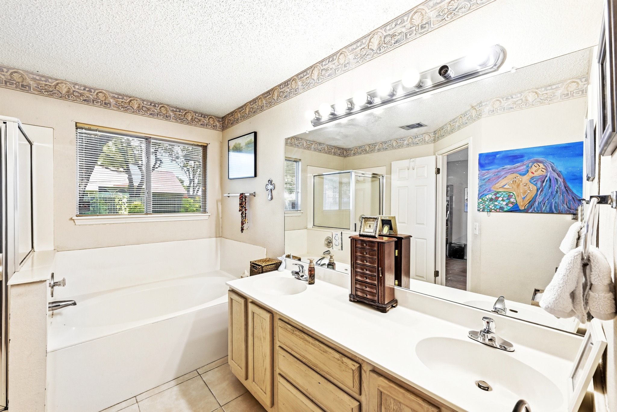 6412 Colton-Bluff Springs Road Austin, TX 78744 - Photo 16 of 27 Dual vanities and a deep soaking tub create a luxurious primary bathroom retreat.