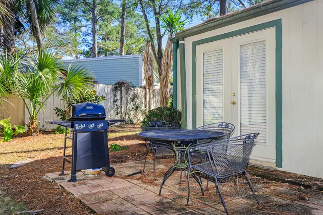 a patio with table and chairs and potted plants