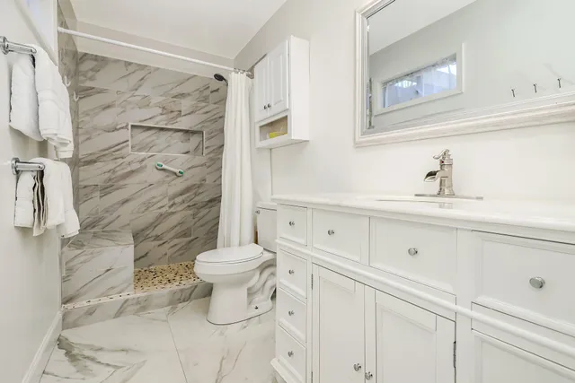 a bathroom with a sink toilet and shower