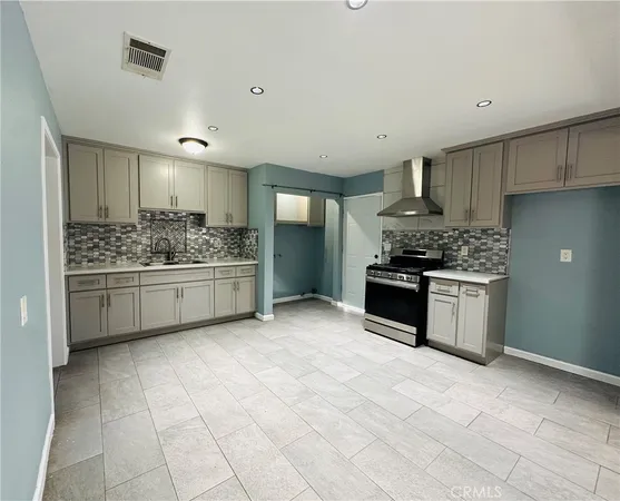 a kitchen with stainless steel appliances a stove sink and cabinets
