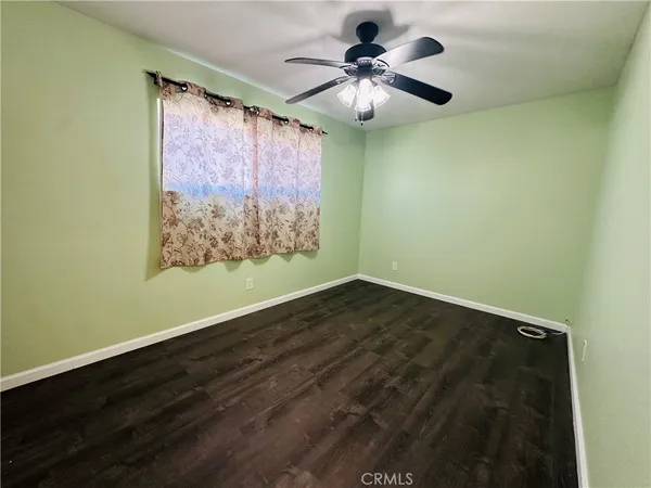 a view of an empty room with a chandelier fan