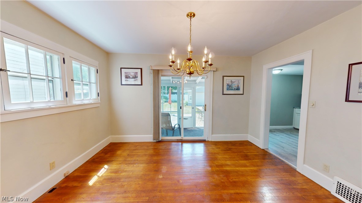 3988 Navahoe Road Cleveland Heights, OH 44121 - Photo 7 of 31 Unfurnished dining area with wood-type flooring and a notable chandelier