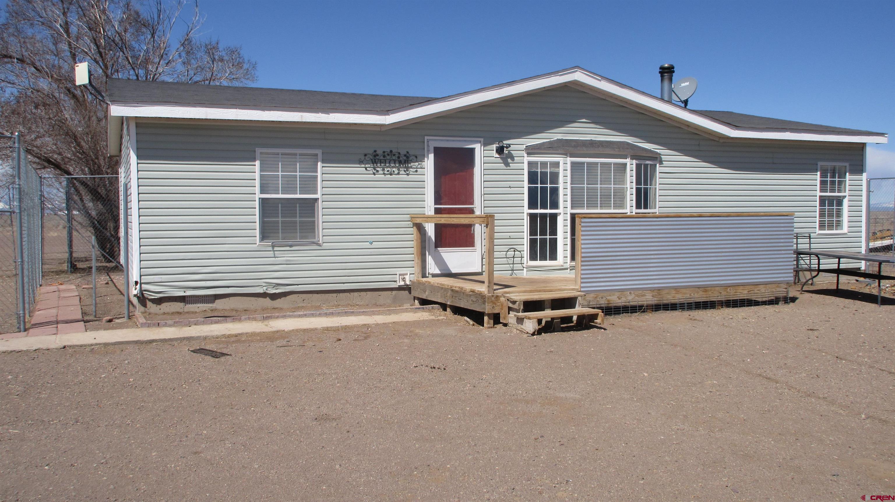 61401 County Road B Center, CO 81125 - Photo 2 of 8 a front view of a house with garage