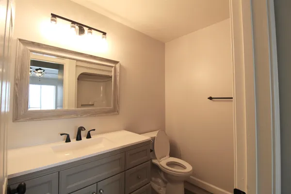 a bathroom with a granite countertop sink a toilet and a mirror