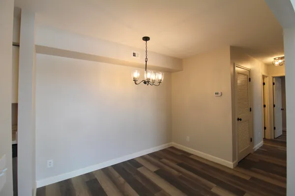 a view of a room with wooden floor and white walls