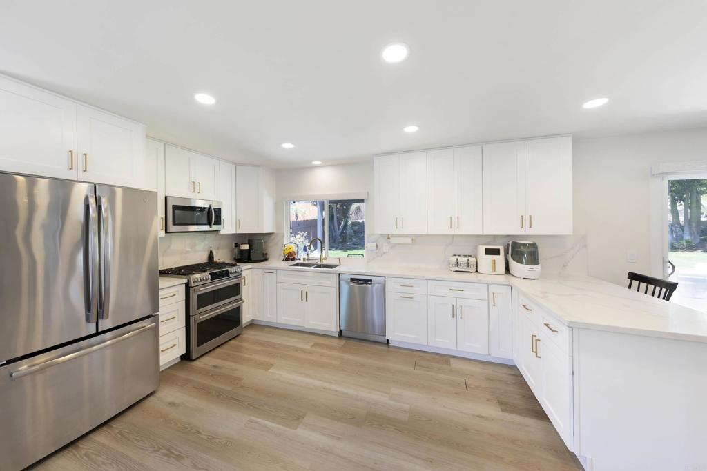 3577 Winslow Road Oceanside, CA 92056 - Photo 9 of 53 a kitchen with white cabinets and stainless steel appliances