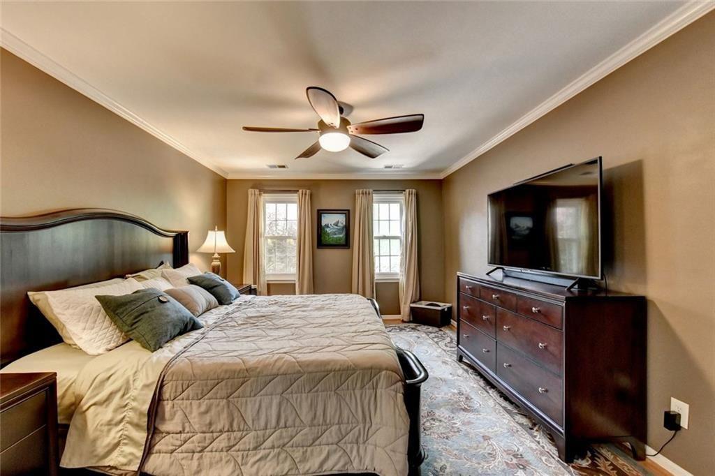 3310 Danielle Way Suwanee, GA 30024 - Photo 12 of 31 a bedroom with a large bed and a flat tv screen on dresser