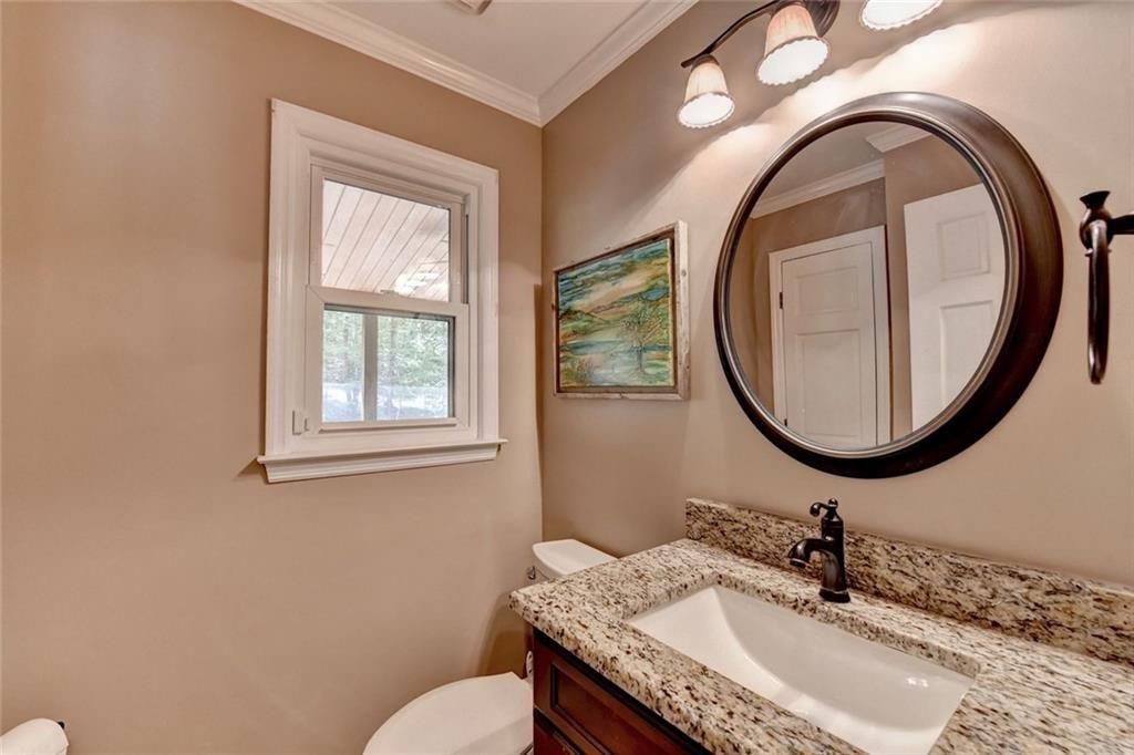 3310 Danielle Way Suwanee, GA 30024 - Photo 6 of 31 a bathroom with a granite countertop toilet a sink and a mirror