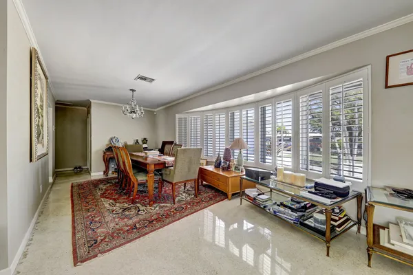 a living room with furniture floor to ceiling window and wooden floor