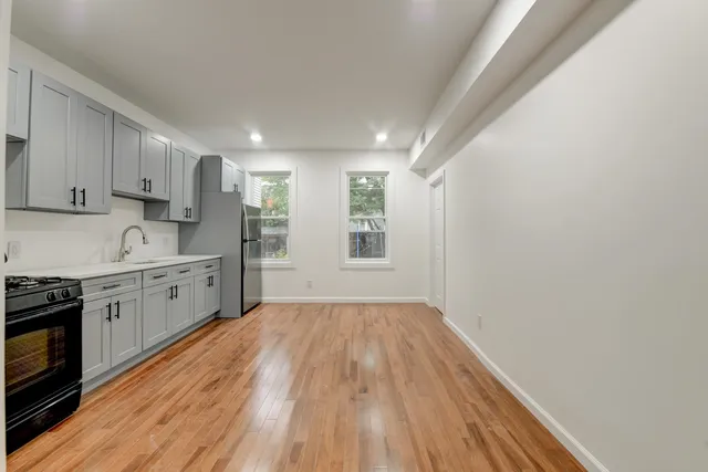 a kitchen with wooden floors and white cabinets
