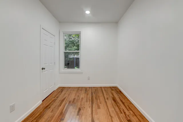a view of a room with wooden floor and window