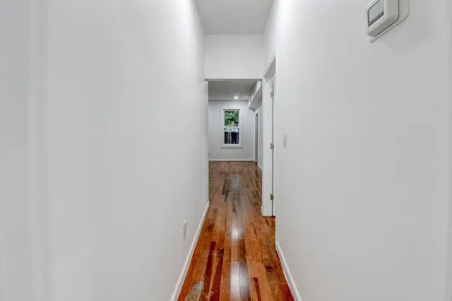 a view of a hallway with wooden floor