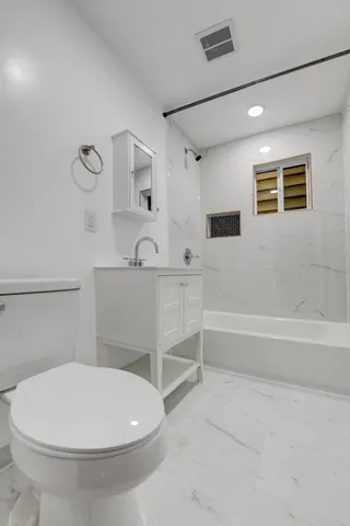 a bathroom with a white toilet and a tub