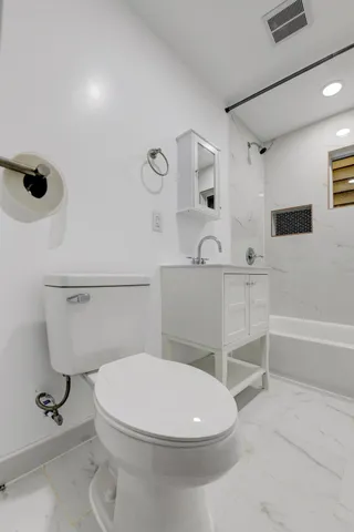 a bathroom with a toilet and a shower