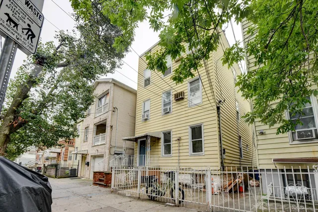 a view of a white house with a large windows and large tree