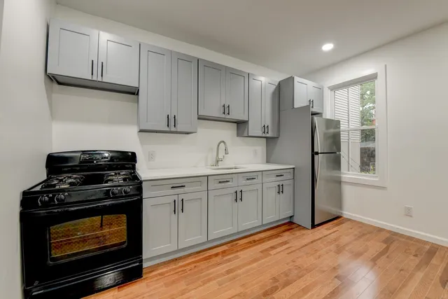 a kitchen with stainless steel appliances granite countertop a stove a sink and a refrigerator
