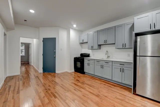a kitchen with a refrigerator stove top oven and cabinets