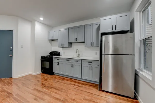a kitchen with stainless steel appliances granite countertop a refrigerator sink and white cabinets