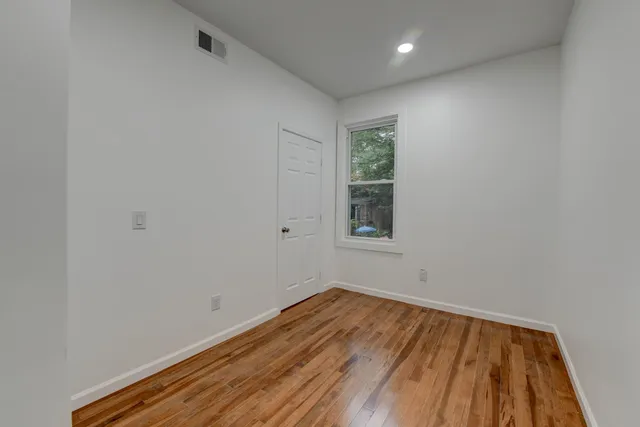 a view of a room with wooden floor and natural light