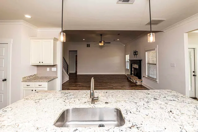 a kitchen with a sink a counter top space appliances and cabinets