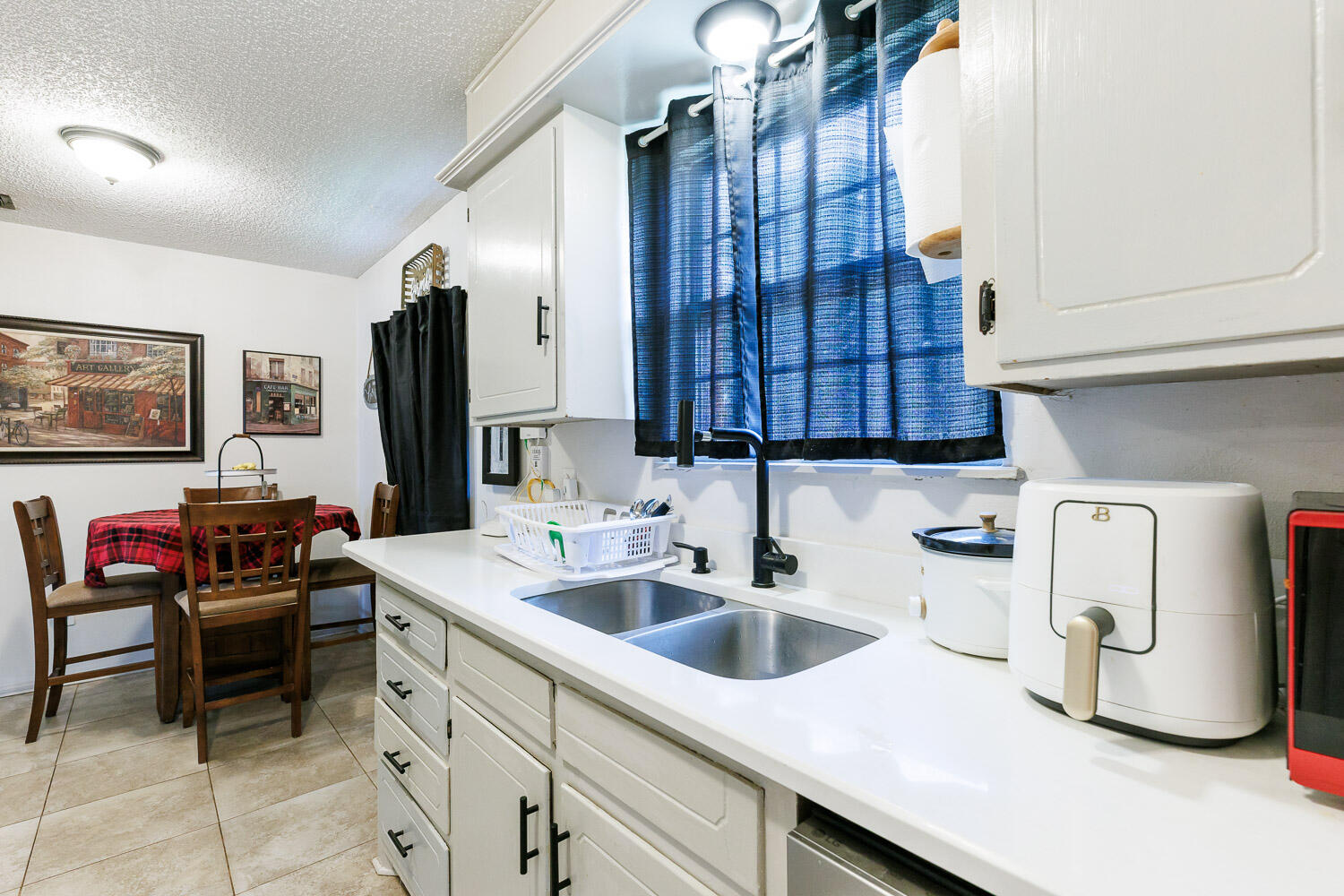 4609 Kemper Street Lubbock, TX 79416 - Photo 12 of 33 a kitchen with a sink and a refrigerator