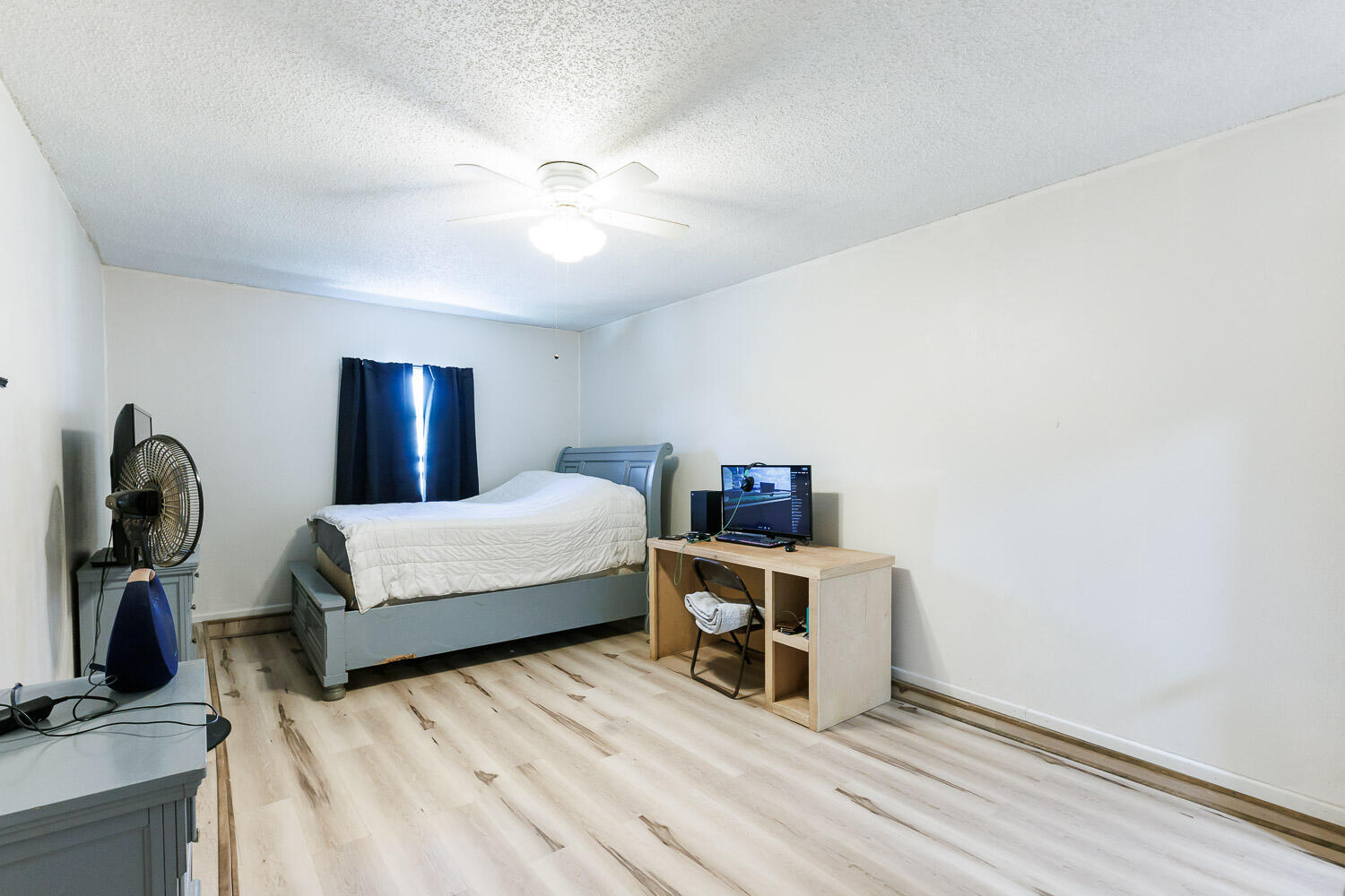 4609 Kemper Street Lubbock, TX 79416 - Photo 27 of 33 a bedroom with a bed wooden floor and lamp
