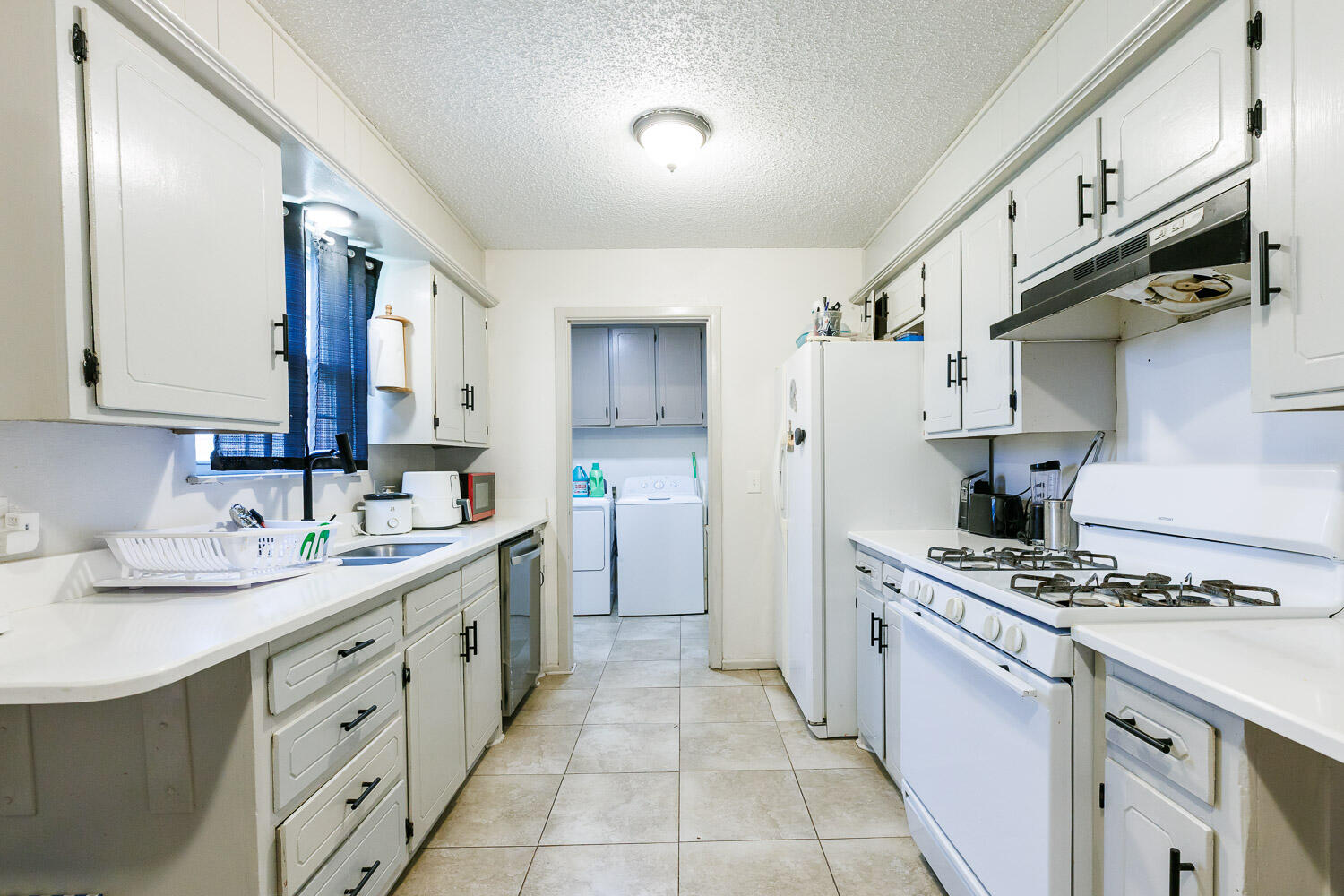 4609 Kemper Street Lubbock, TX 79416 - Photo 4 of 33 a kitchen with stainless steel appliances a sink stove and cabinets