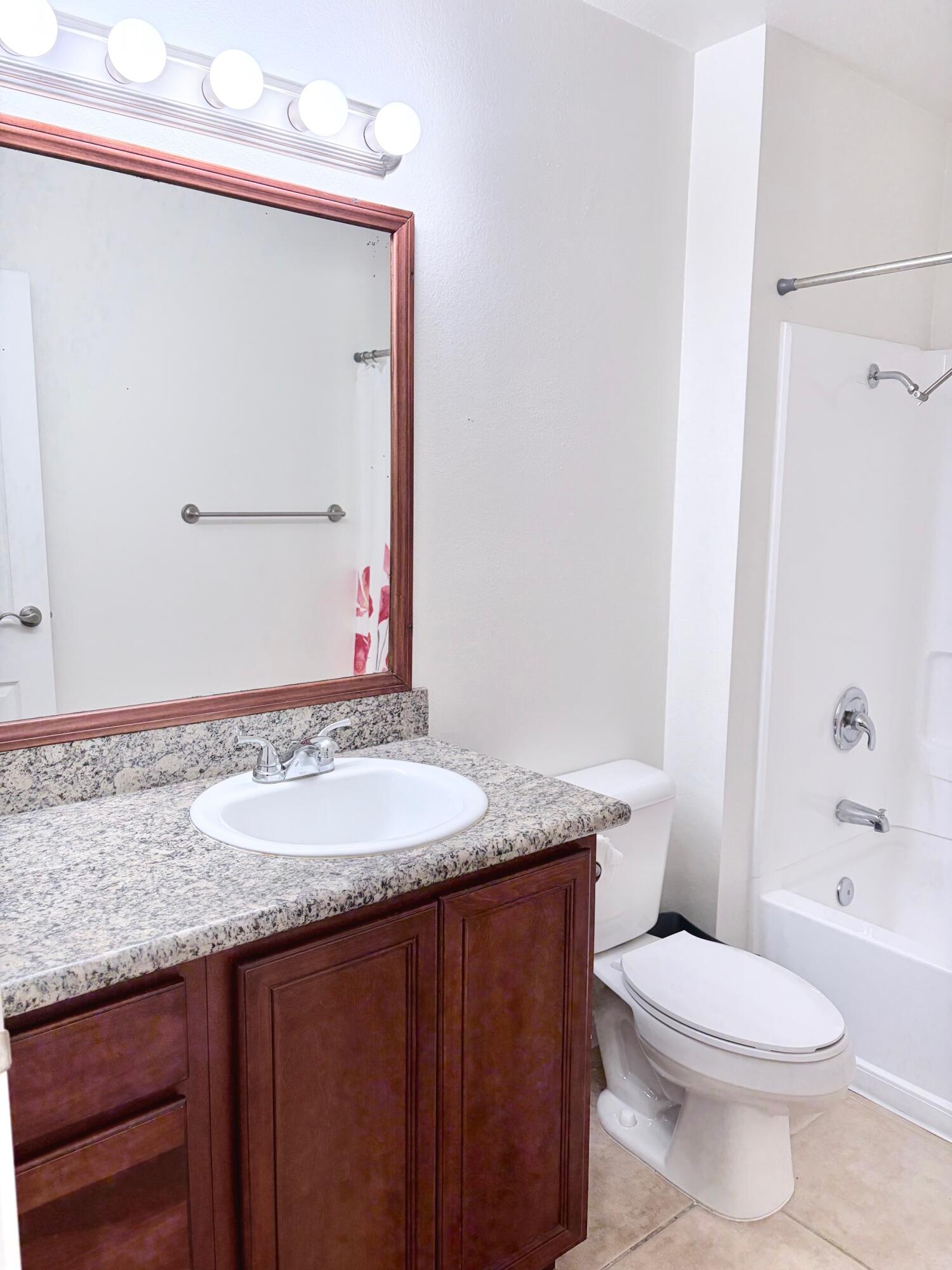 43376 Cook Street, Unit 32 Palm Desert, CA 92211 - Photo 15 of 31 a bathroom with a granite countertop sink a toilet and a mirror