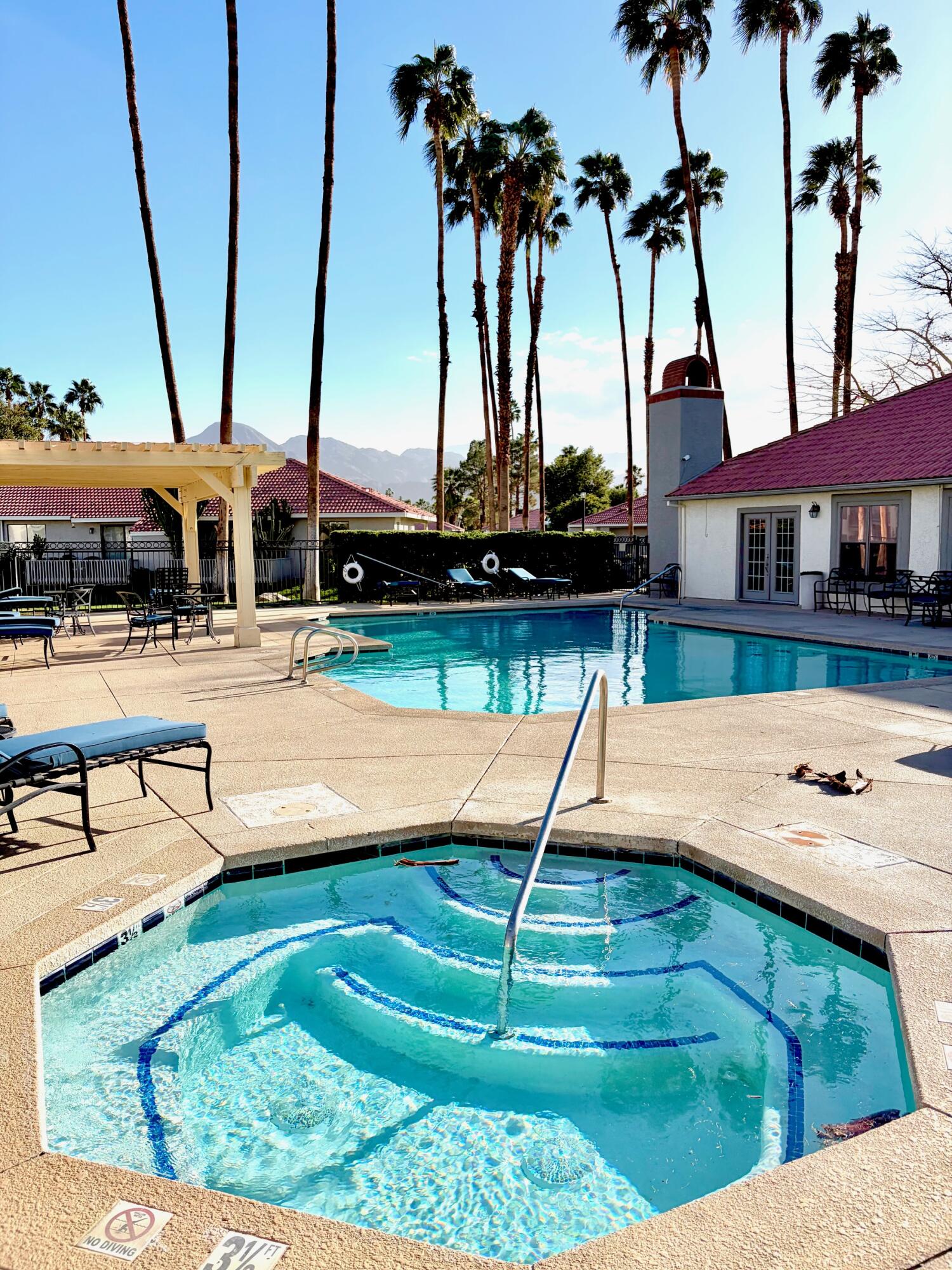 43376 Cook Street, Unit 32 Palm Desert, CA 92211 - Photo 24 of 31 a view of a swimming pool with a lawn chairs and a yard